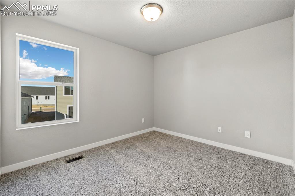 Image 28 of 38: Unfurnished room with carpet