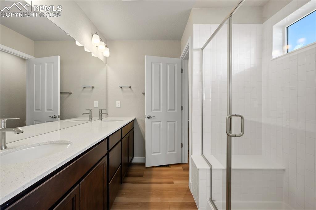 Image 33 of 38: Bathroom with double vanity, and a stall shower