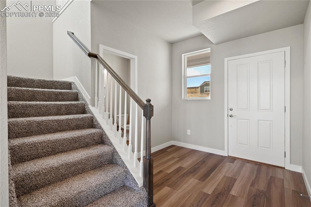 Image 9 of 38: Entryway with dark wood finished floors and stairway