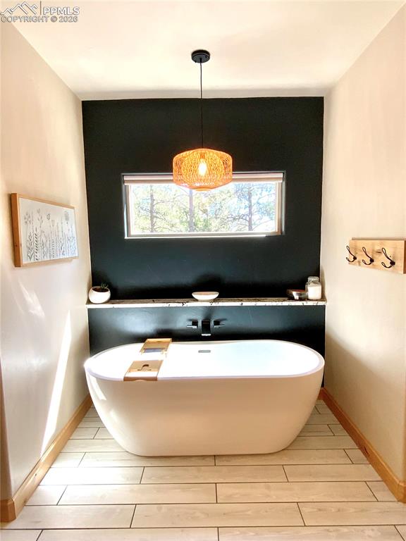 Image 16 of 47: Full bath with a freestanding bath and wood-look tiled floors