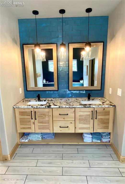 Image 17 of 47: Primary en-suite bathroom with double vanity and wood-look tiled floors