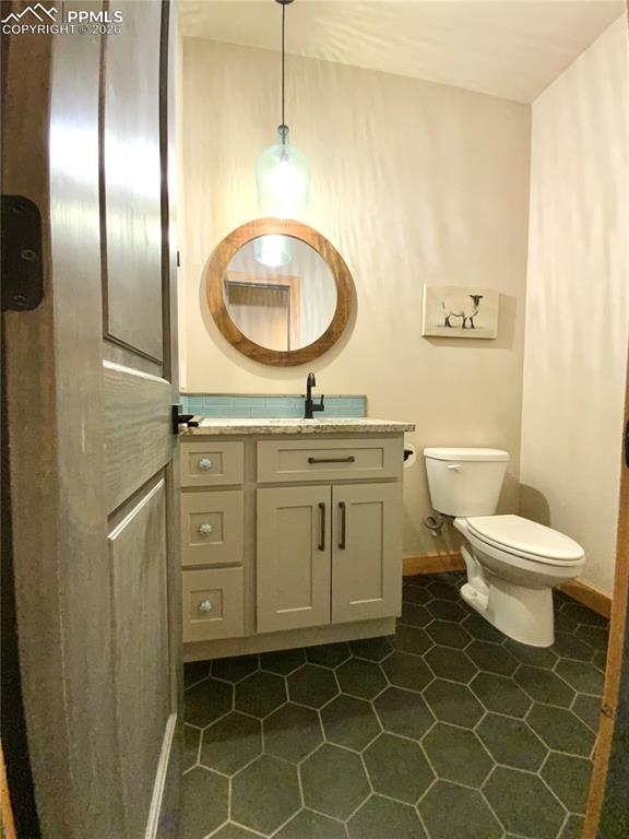 Image 22 of 47: Half bath featuring vanity and dark tile patterned floors
