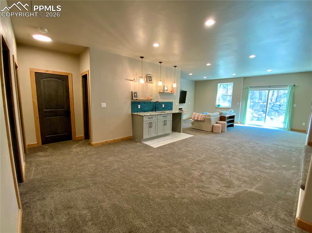 Image 28 of 47: Basement living space with natural light, walkout sliding door to side pati