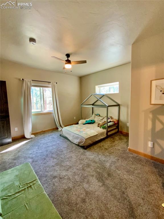 Image 30 of 47: Carpeted bedroom featuring ceiling fan and en-suite bathroom