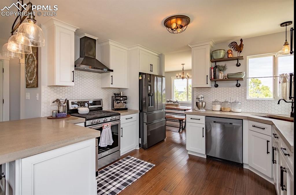 Image 10 of 44: Kitchen featuring decorative light fixtures, stainless steel appliances, wa