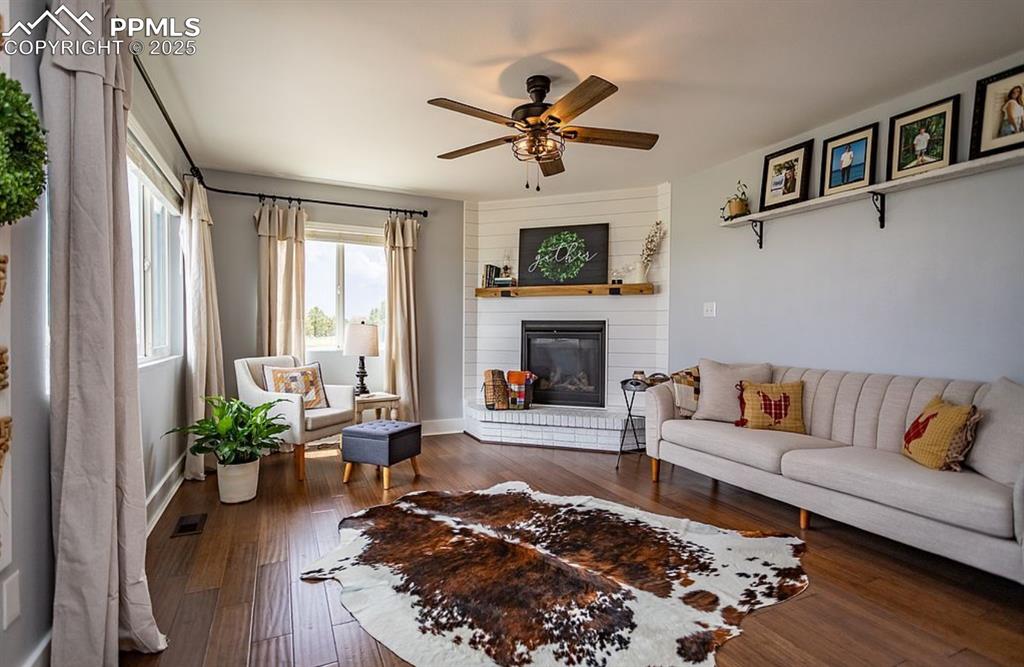 Image 12 of 44: Living area with a large fireplace, dark wood finished floors, and ceiling 