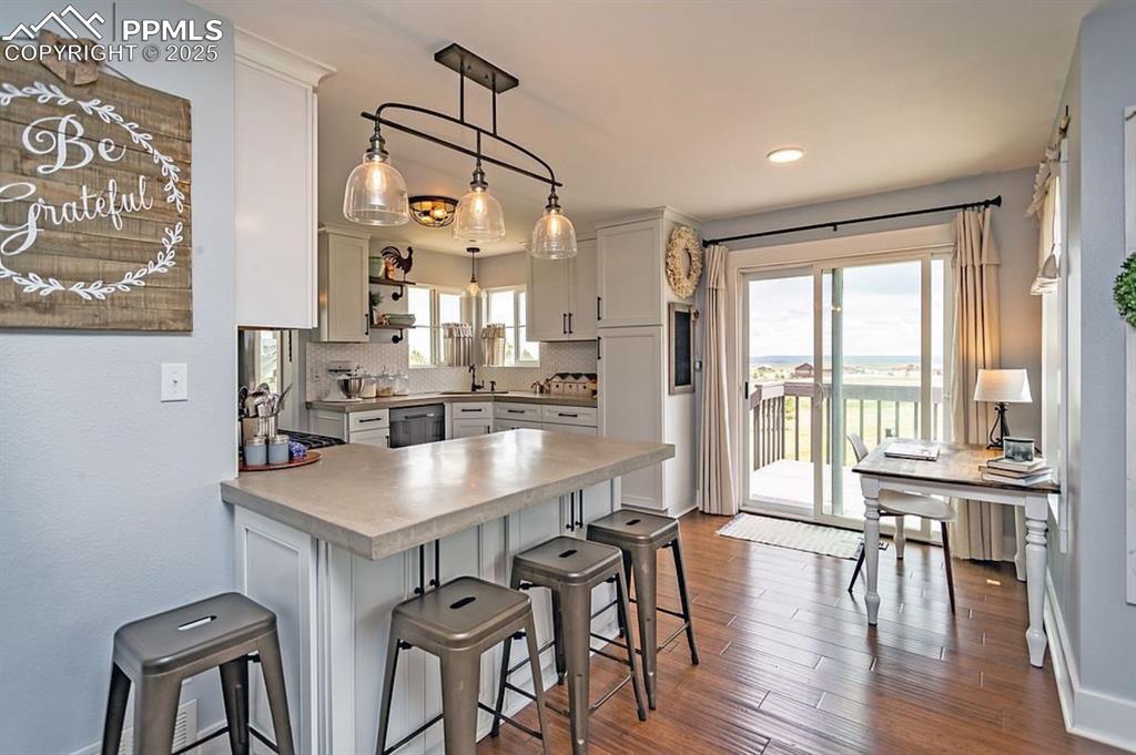 Image 14 of 44: Kitchen featuring a peninsula, pendant lighting, a kitchen breakfast bar, b