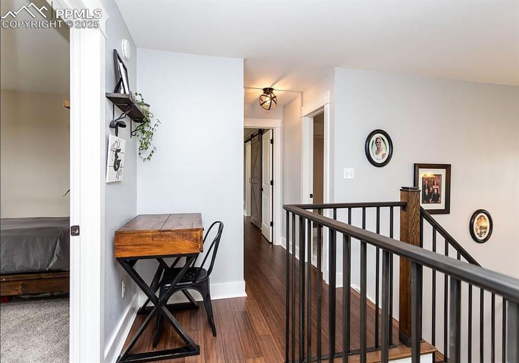 Image 17 of 44: Corridor with dark wood finished floors and an upstairs landing