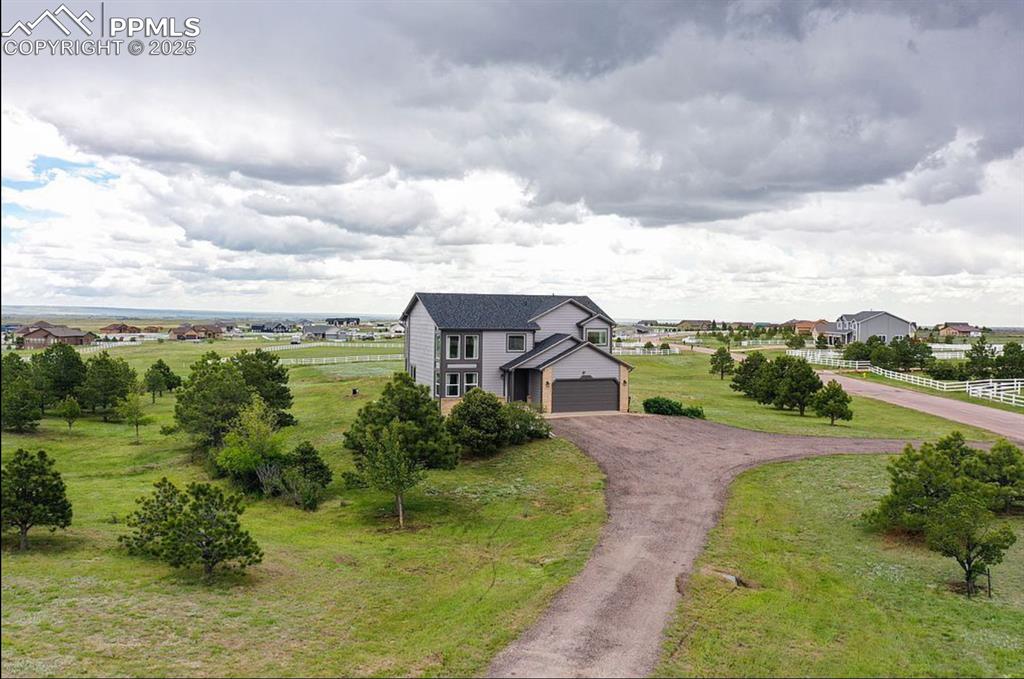 Image 2 of 44: View of front of home with dirt driveway, a garage, and a front yard