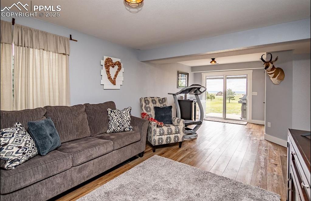Image 25 of 44: Living area with light wood-style floors and baseboards