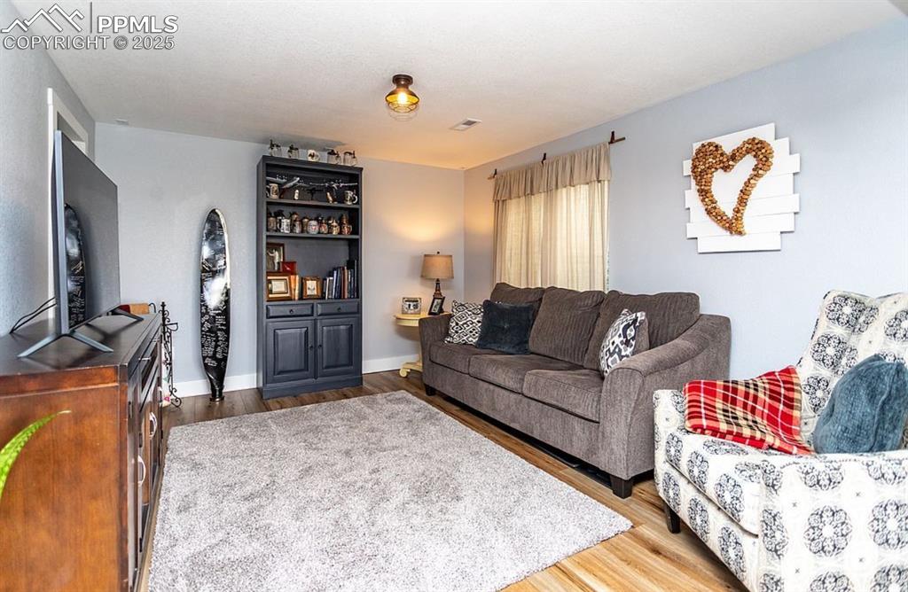 Image 26 of 44: Living area with light wood-style flooring and baseboards