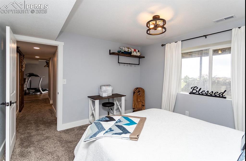 Image 29 of 44: Bedroom with dark carpet and baseboards