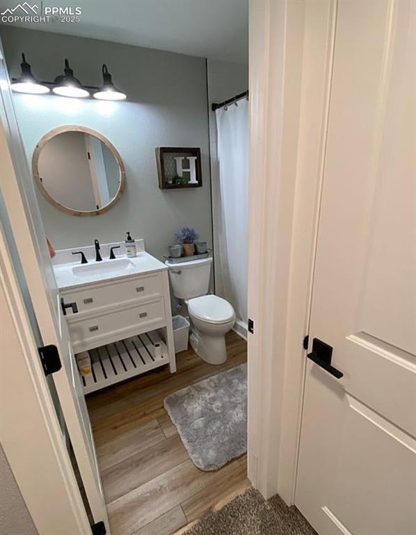 Image 30 of 44: Bathroom featuring vanity, light wood finished floors, and a shower with cu