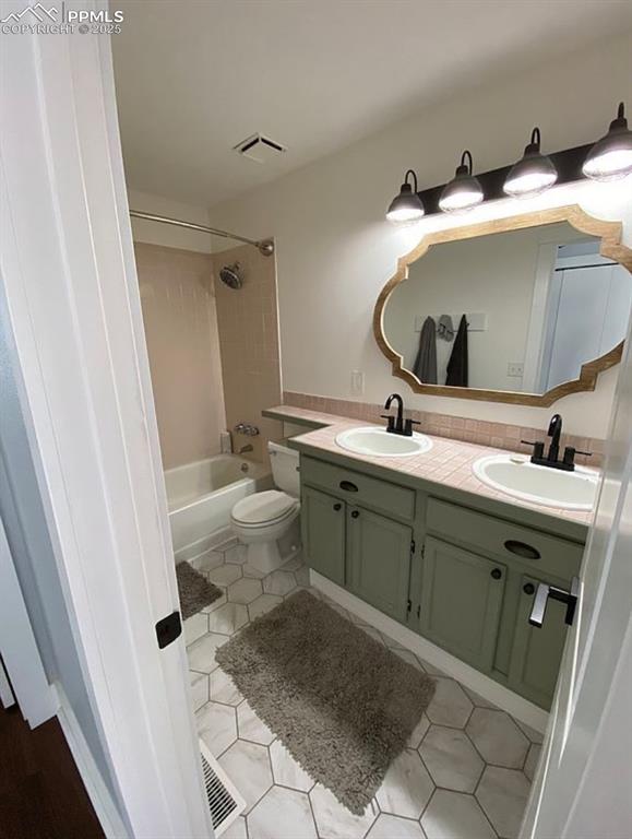 Image 31 of 44: Full bathroom featuring double vanity, washtub / shower combination, and li