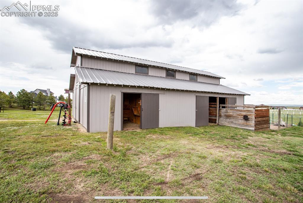 Image 37 of 44: View of side of property with an outbuilding, a metal roof, and an exterior