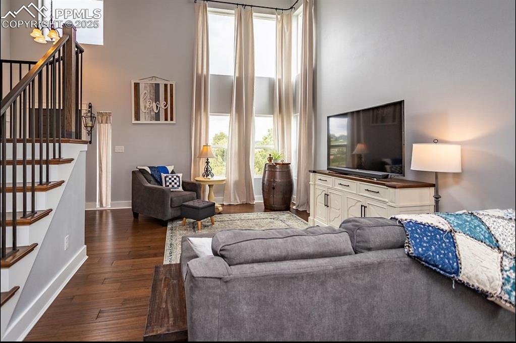 Image 6 of 44: Living area with stairs, hardwood / wood-style flooring, a chandelier, and 
