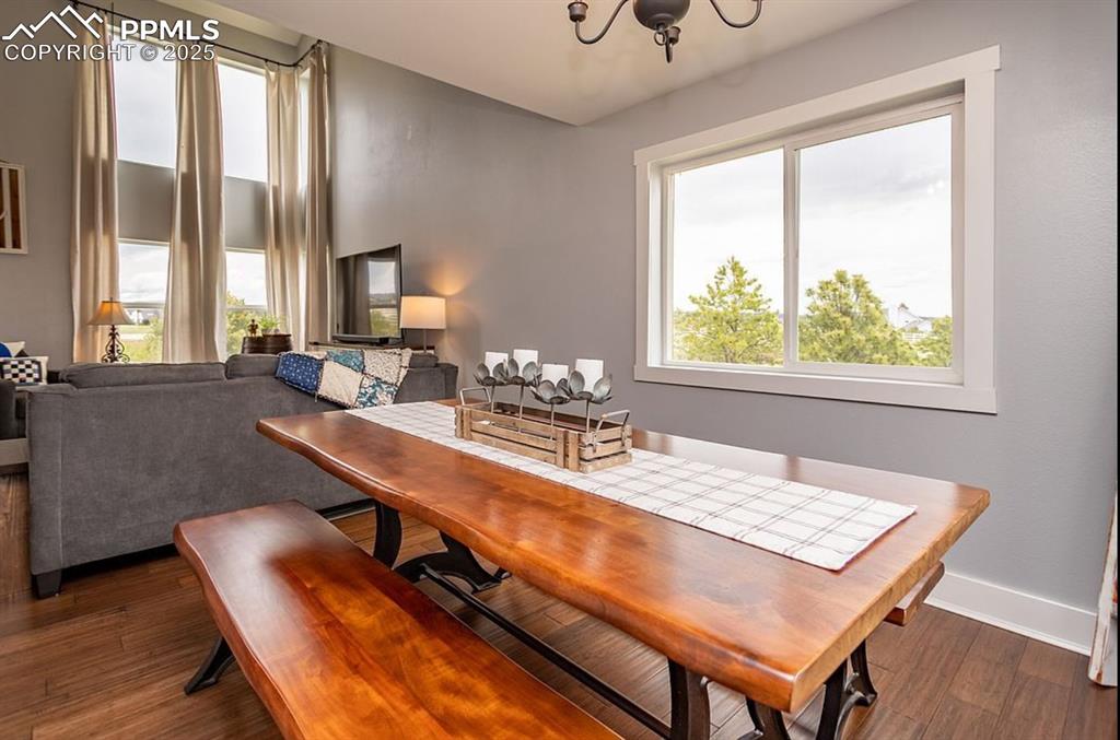 Image 8 of 44: Dining room with dark wood-type flooring and a chandelier