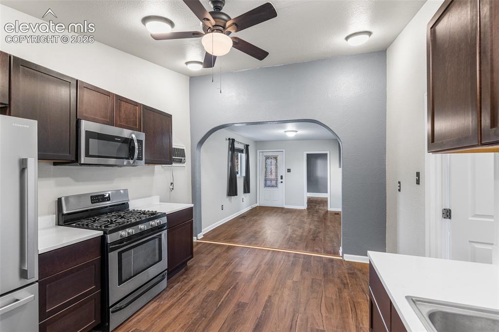 Image 11 of 32: Kitchen featuring dark cabinetry, white countertops, stainless steel gas ra