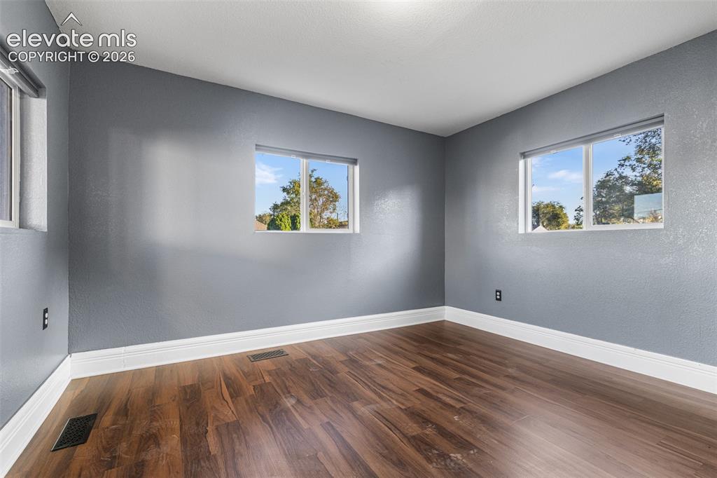 Image 12 of 32: Room featuring wood-finish flooring, neutral-toned walls, and multiple dual