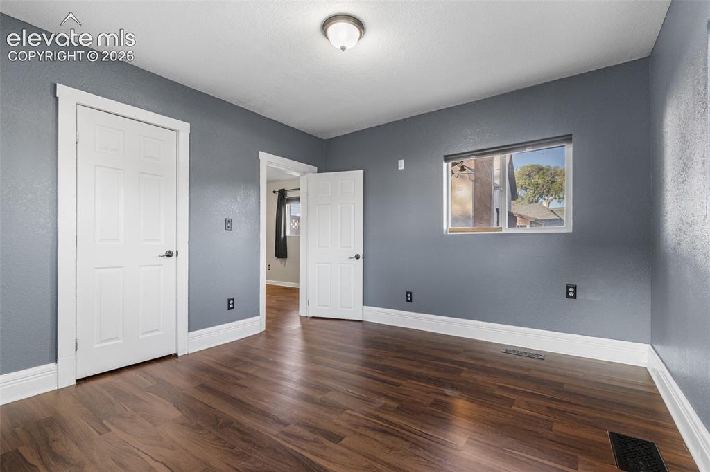 Image 13 of 32: Wood-finish flooring, neutral gray wall paint, flush-mount ceiling lighting