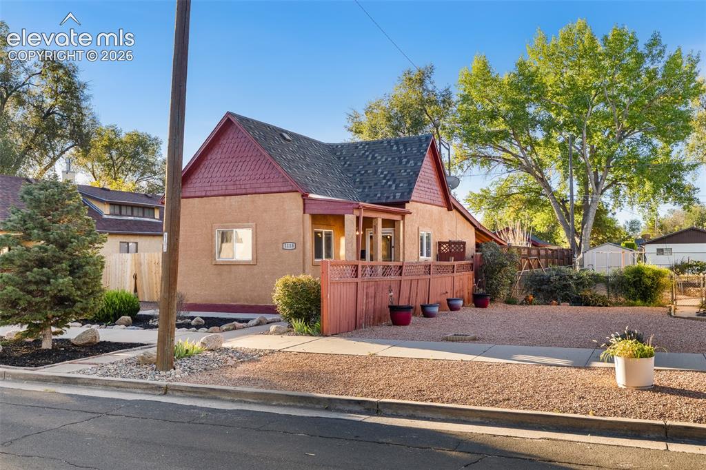 Image 2 of 32: Stucco exterior with textured shingle roof detailing, covered front porch, 
