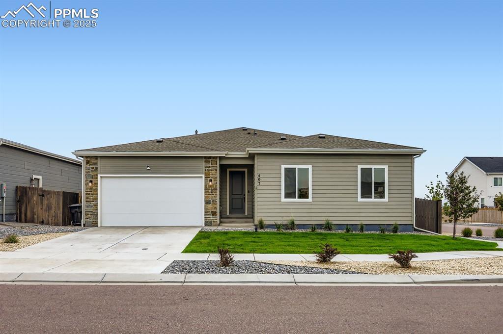 Caption: Single story home with concrete driveway, roof with shingles, an attached garage, and stone siding