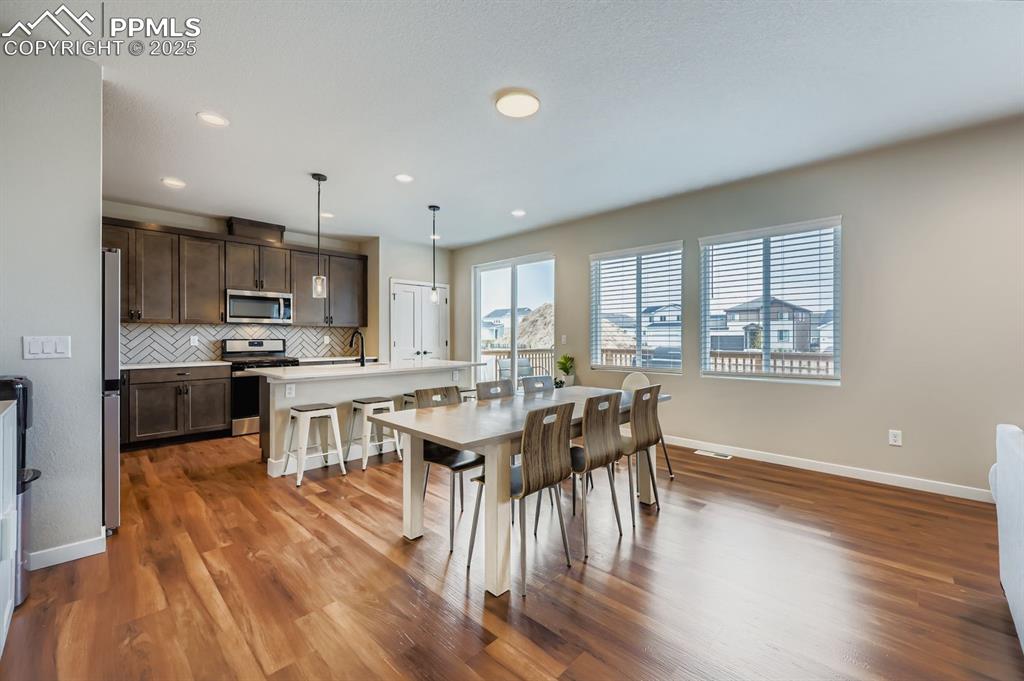 Image 10 of 28: Dining area featuring dark wood-style floors and recessed lighting