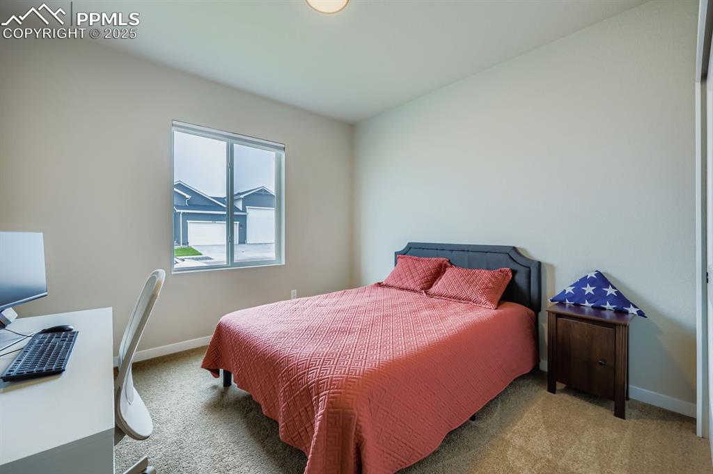Image 14 of 28: Carpeted bedroom with baseboards and an office area