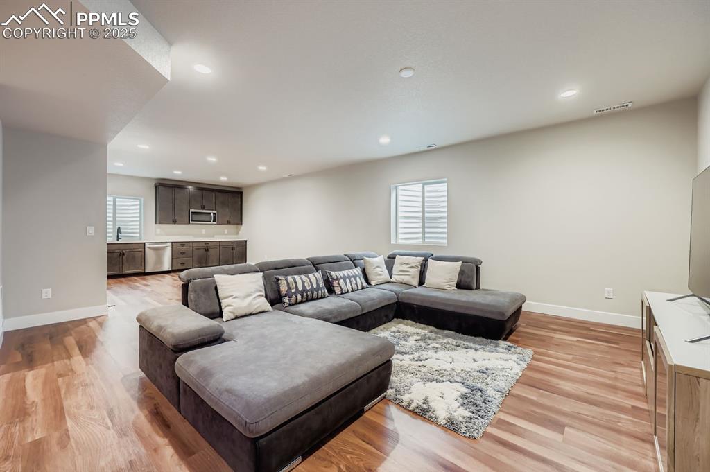 Image 19 of 28: Living area featuring light wood-type flooring and recessed lighting