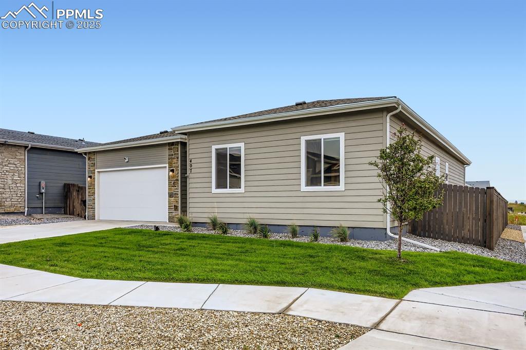 Image 2 of 28: View of front facade featuring an attached garage and concrete driveway