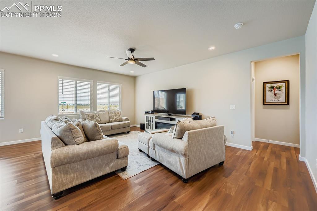 Image 5 of 28: Living room featuring ceiling fan, recessed lighting, and wood finished flo
