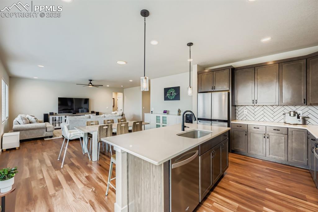 Image 8 of 28: Kitchen with stainless steel appliances, pendant lighting, a center island 