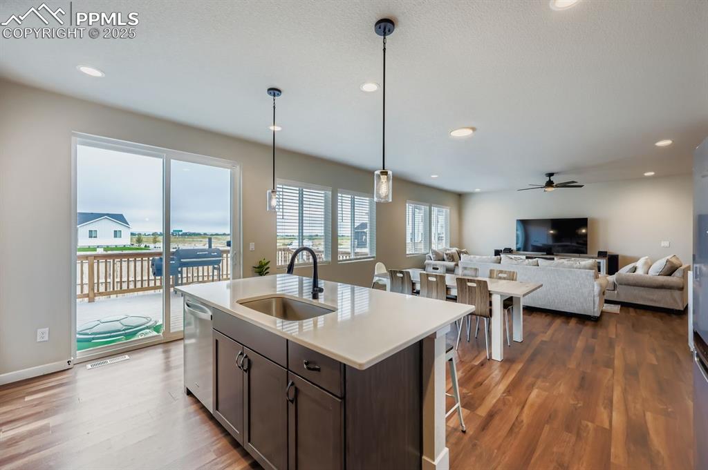 Image 9 of 28: Kitchen featuring hanging light fixtures, open floor plan, dark brown cabin