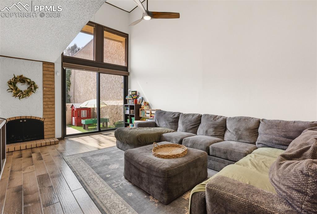 Image 7 of 26: Vaulted ceiling, tall windows, access to patio, and cozy fireplace making t