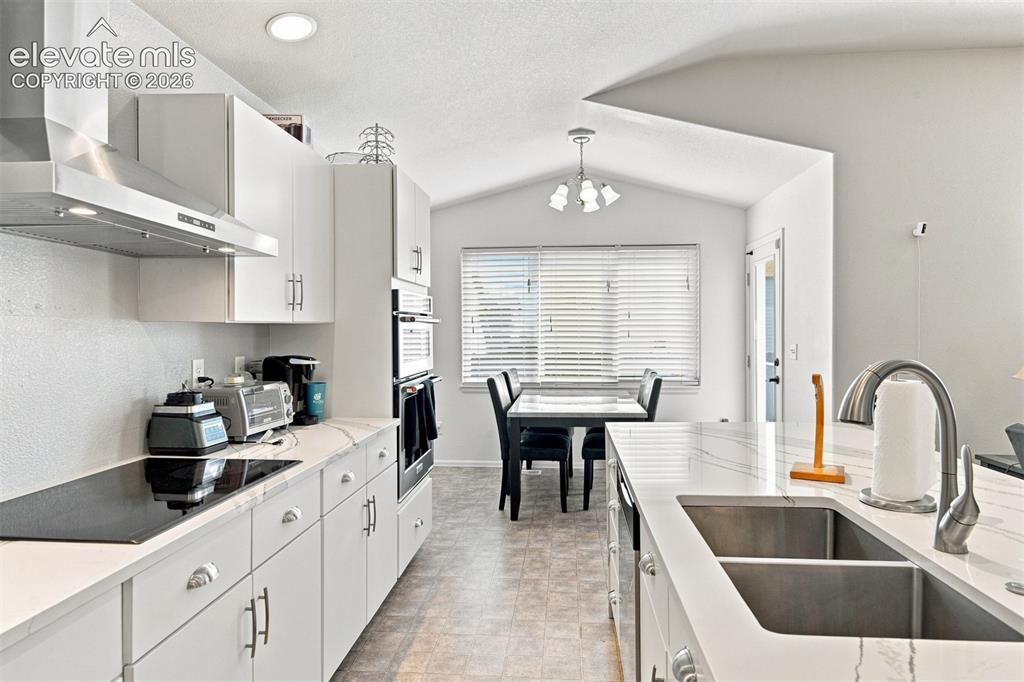 Image 10 of 32: Kitchen featuring white cabinetry, a double basin sink, stainless steel app
