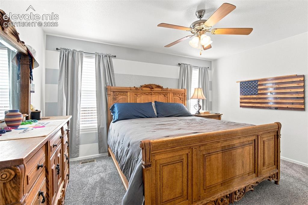 Image 13 of 32: Ceiling fan with light fixture, window with blinds and curtains, wall with 
