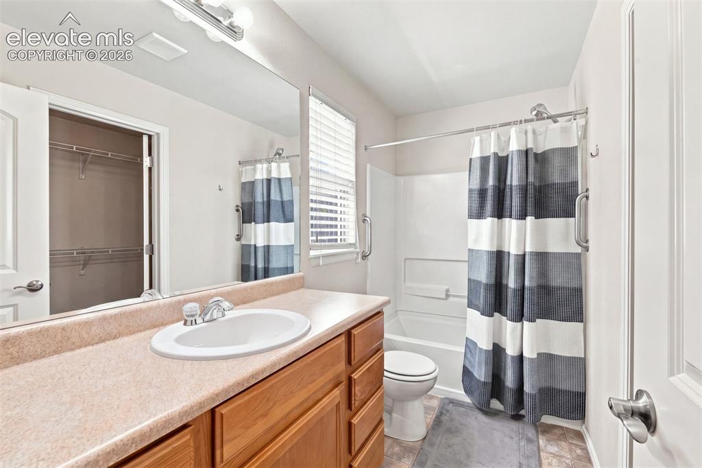 Image 15 of 32: Bathroom featuring a wood-tone vanity with an integrated sink, a full-width