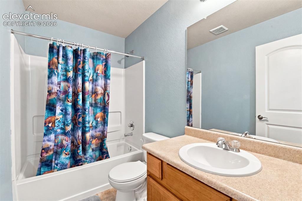 Image 19 of 32: Bathroom featuring a vanity with a laminate countertop, an oval sink, and a