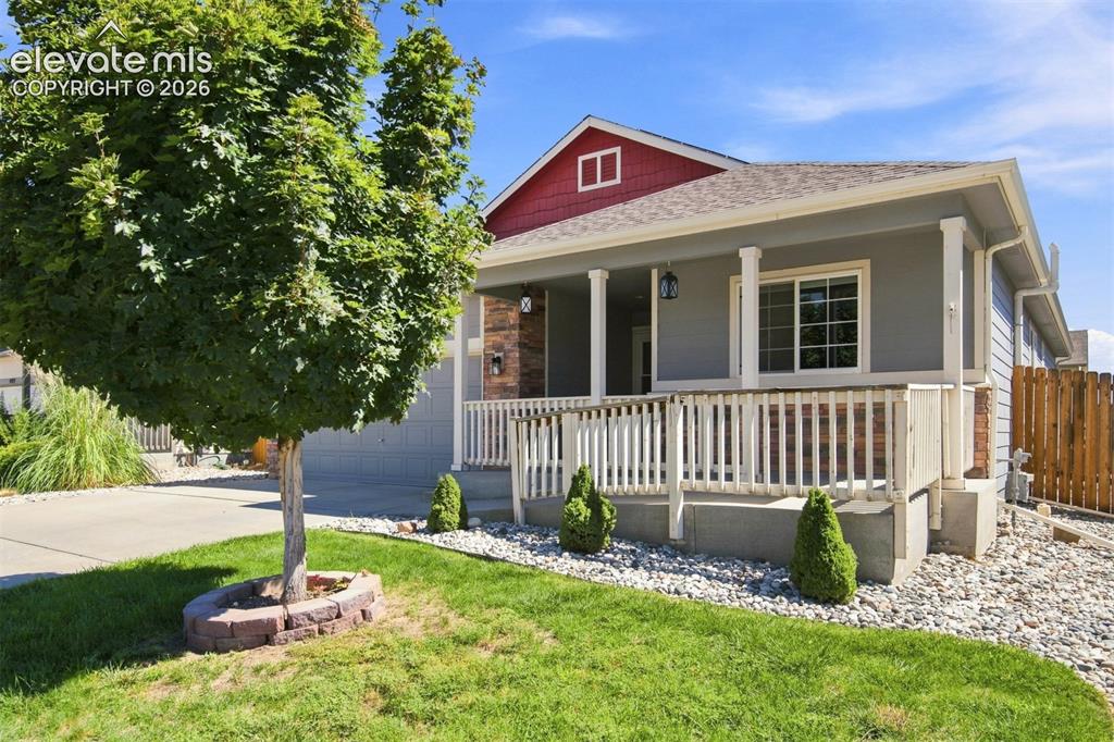 Image 2 of 32: Front exterior featuring a covered porch with white railings and columns, a