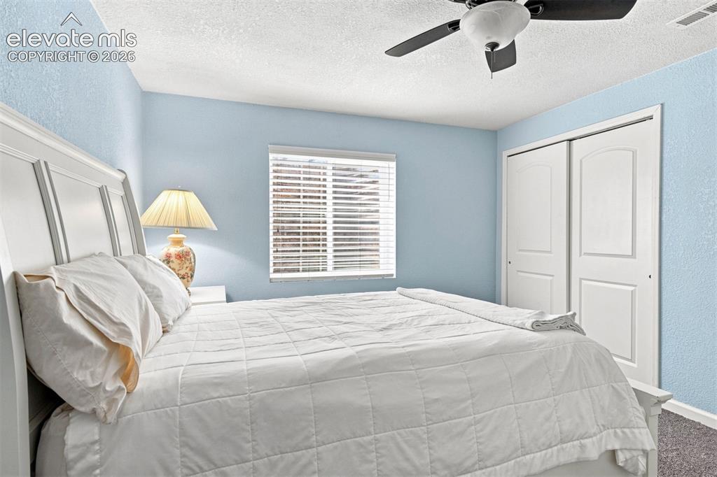 Image 28 of 32: Window with horizontal blinds, built-in ceiling fan with integrated lightin
