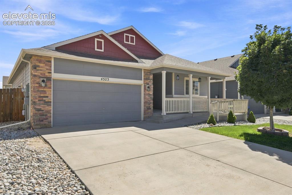 Image 3 of 32: Exterior featuring stone veneer accents, covered front porch, integrated fr