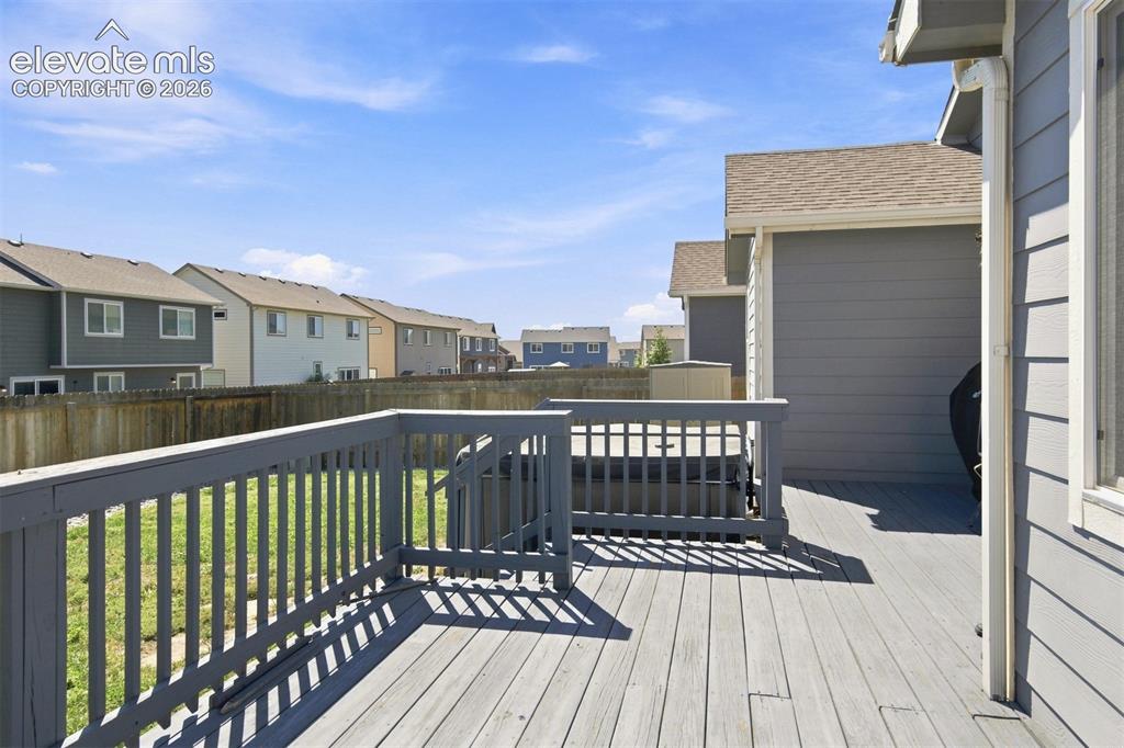 Image 30 of 32: Expansive back deck, wood privacy fence, and manicured lawn