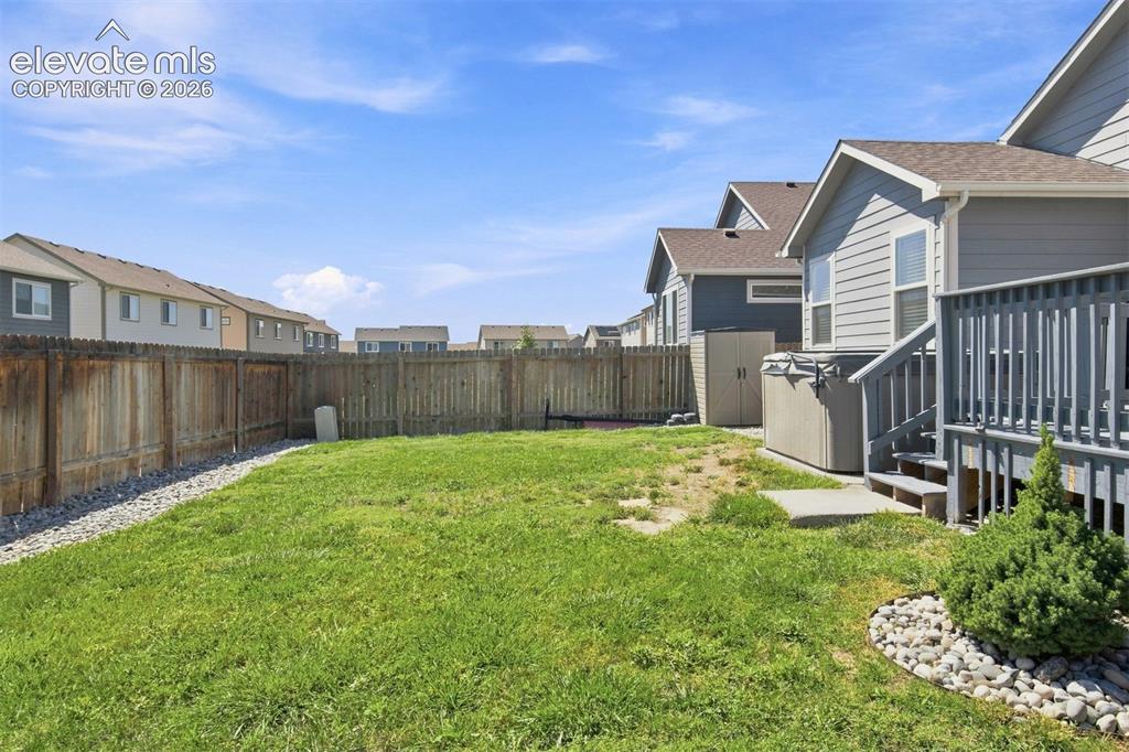 Image 31 of 32: Expansive backyard featuring a wood privacy fence, concrete patio, and an o