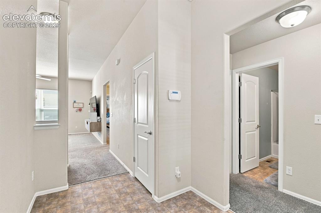 Image 5 of 32: Neutral wall paint, recessed lighting, panel doors, and mixed flooring mate