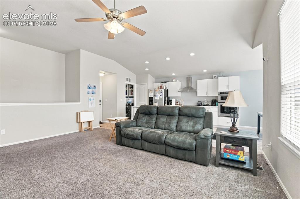 Image 8 of 32: Vaulted ceiling with ceiling fan light fixture, recessed lighting, and kitc