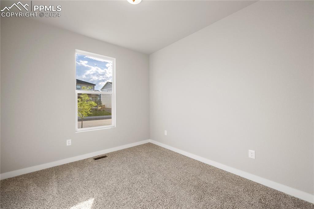 Image 7 of 36: Empty room with carpet floors and a wealth of natural light