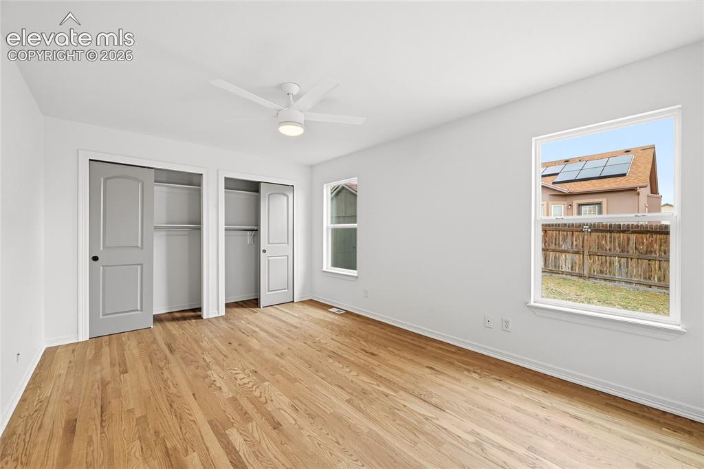 Image 10 of 30: Hardwood flooring throughout, featuring a ceiling fan with integrated light