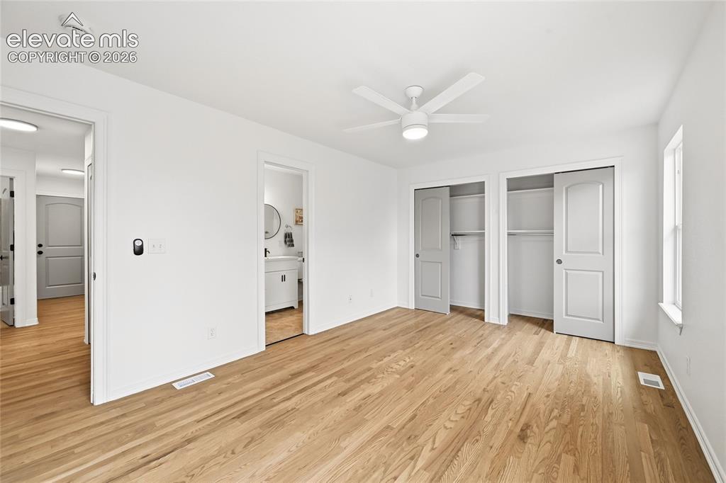 Image 11 of 30: Bright interior with wood-finish flooring, a contemporary ceiling fan, and