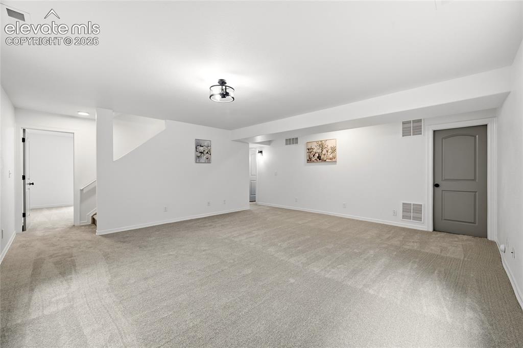 Image 15 of 30: Spacious room featuring light-toned carpeting and neutral walls