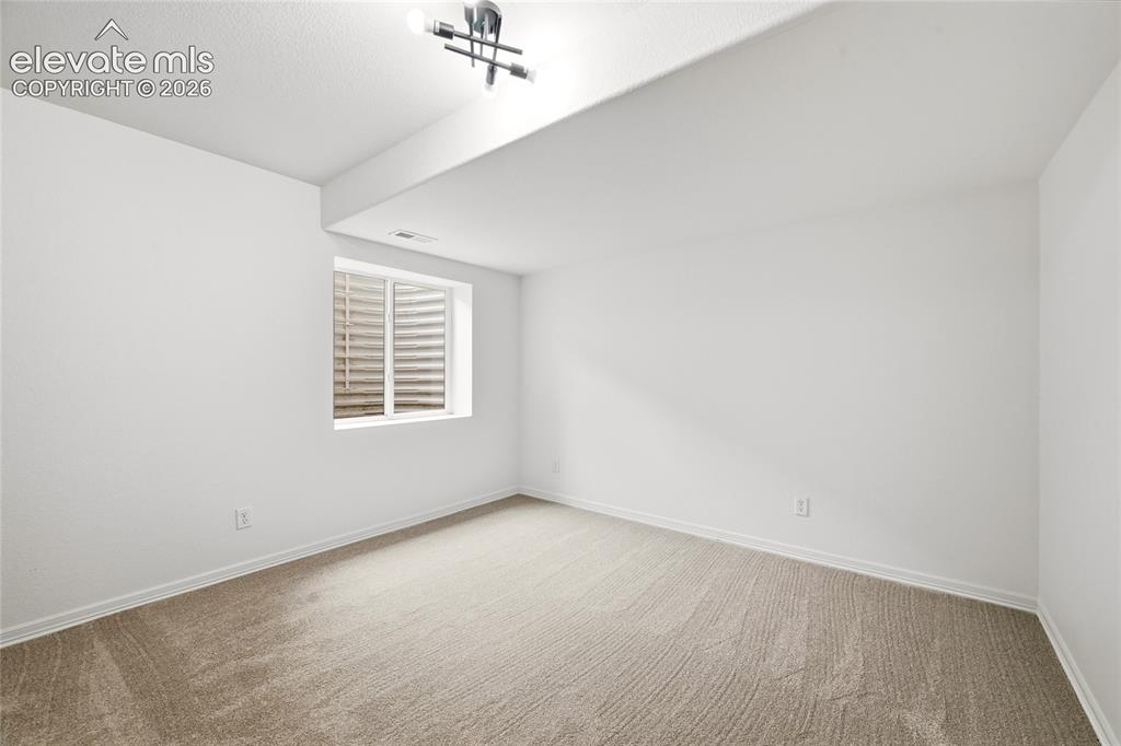 Image 20 of 30: Room featuring neutral carpeting, a white window frame, and a contemporary